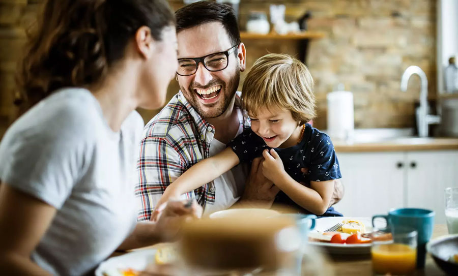 Familie-am-Tisch-sitzend-lachend